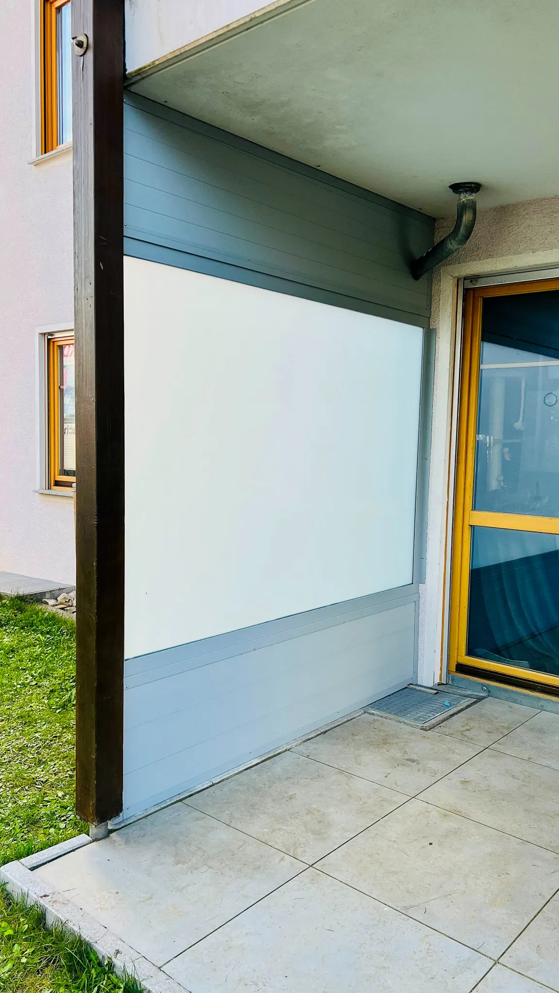 Heller Sichtschutz aus Aluminium-Profilen an Terrassenrand mit Holzpfosten